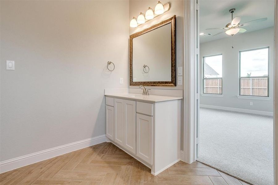 Bathroom with vanity, ceiling fan, and parquet floors