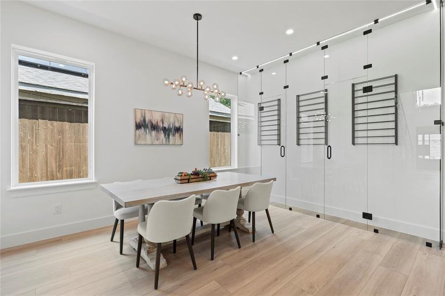 Dining area featuring light wood finished floors, recessed lighting, a chandelier, and healthy amount of natural light
