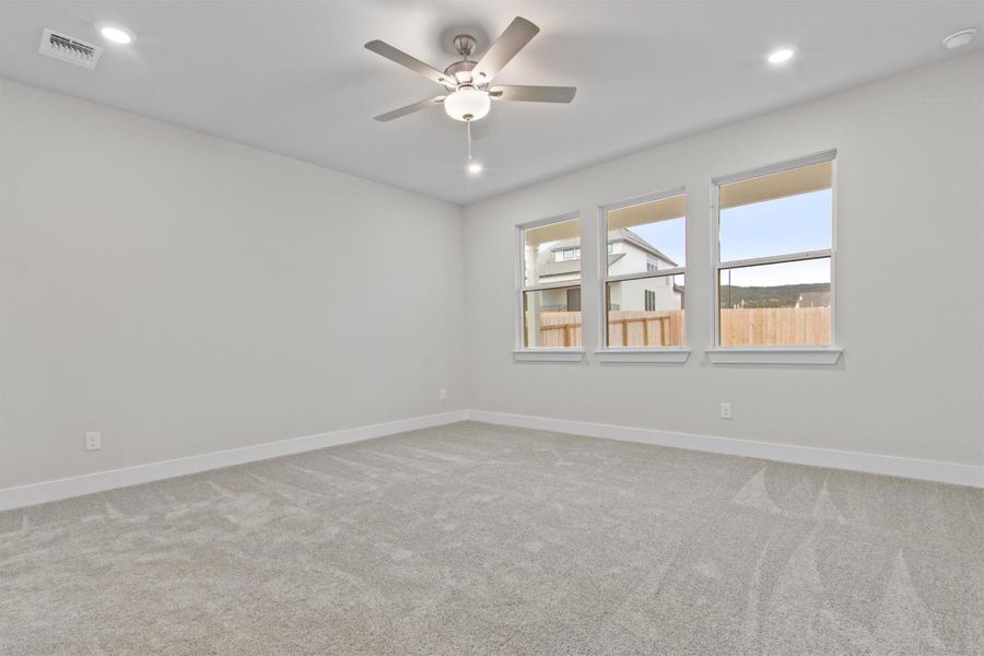 Carpeted spare room featuring ceiling fan