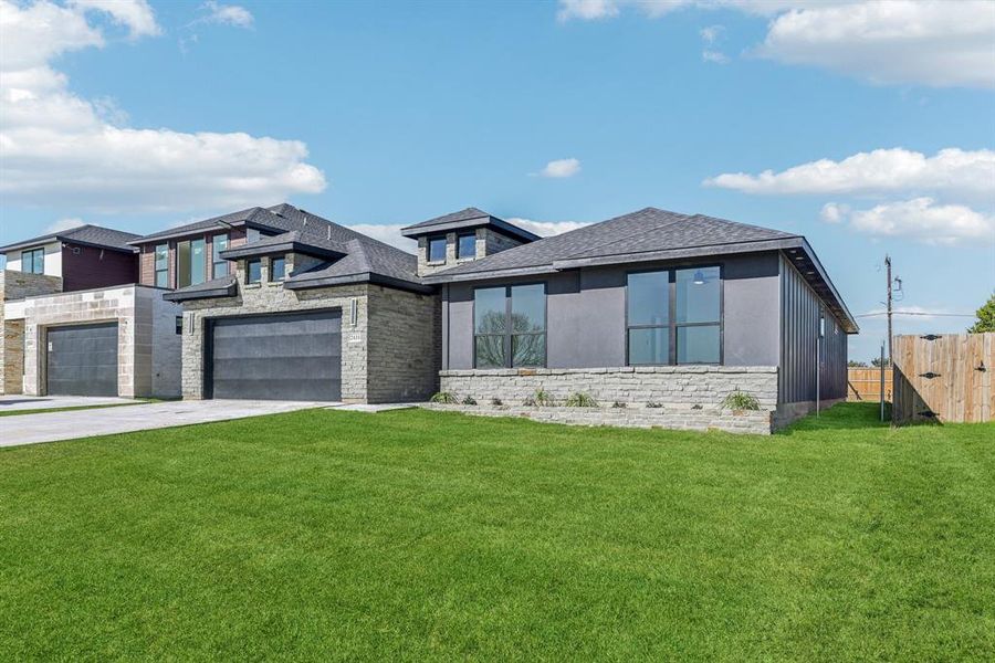 View of front of home with a front yard and a garage