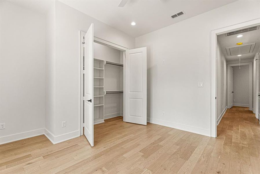 Unfurnished bedroom with attic access, recessed lighting, light wood finished floors, a spacious closet, and a ceiling fan