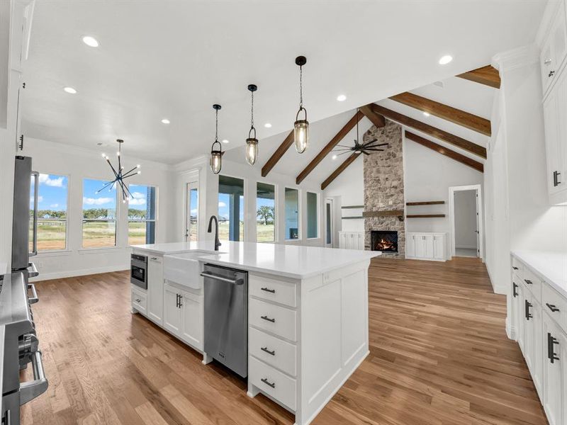 Kitchen featuring light hardwood / wood-style flooring, an island with sink, a healthy amount of sunlight, and appliances with stainless steel finishes