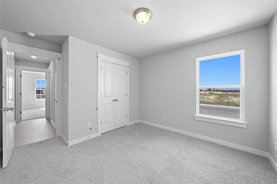Unfurnished bedroom featuring light carpet and a closet Unfurnished bedroom featuring light carpet and a closet
