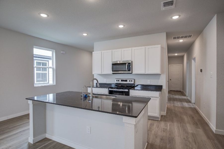 A kitchen with white cabinets.