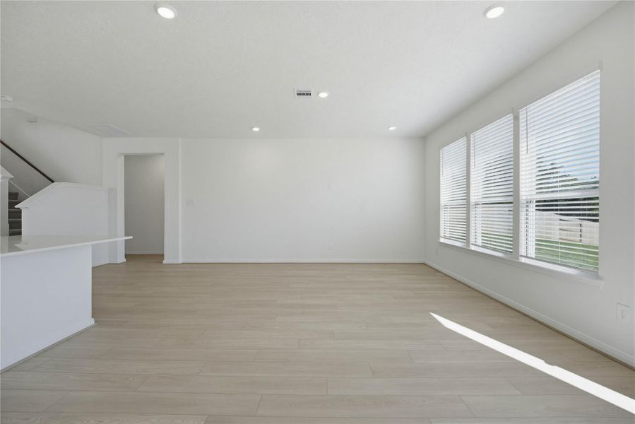 This Great Room is the perfect layout for entertaining or just relaxing. Whether it's simply a night in or entertaining family and friends, this home has ample open space for everyone to enjoy! Featuring vinyl plank flooring, large windows with privacy blinds, high ceilings, recessed lighting and custom paint!