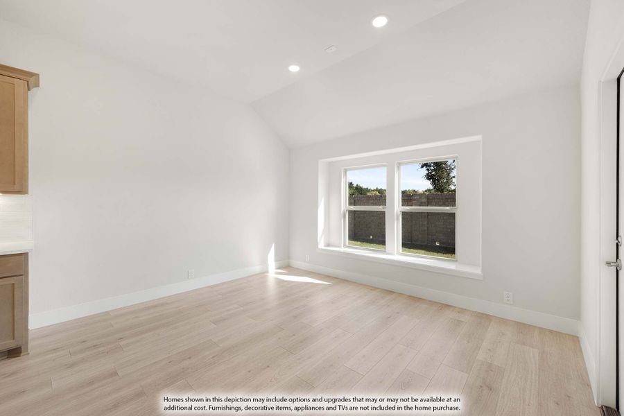 Empty room with vaulted ceiling, light wood floors, and a double window with natural light Empty room with vaulted ceiling, light wood floors, and a double window with natural light