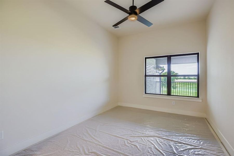 Empty room featuring baseboards and a ceiling fan