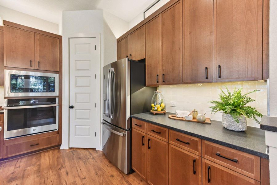 Culinary delights await in this modern kitchen with rich cabinetry and integrated appliances. Culinary delights await in this modern kitchen with rich cabinetry and integrated appliances.