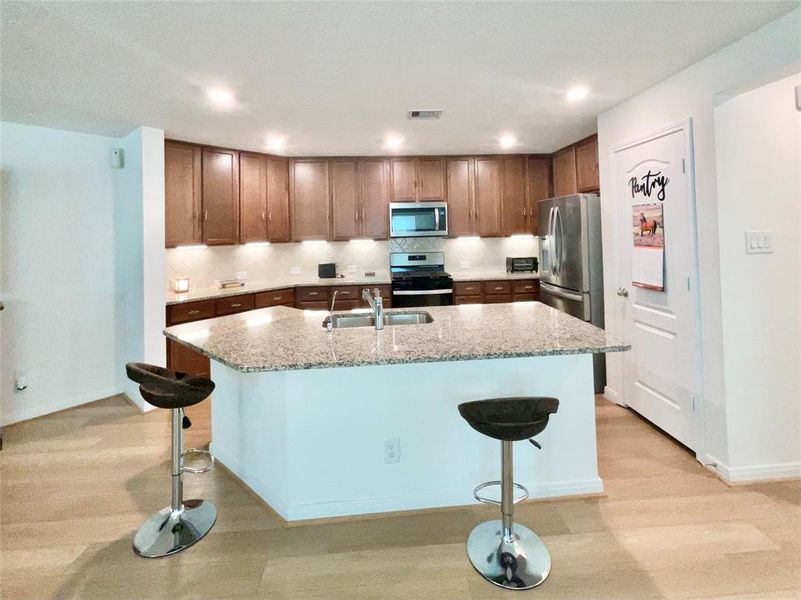 View of Large Breakfast Bar & Sink, 42 inch Cabinetry equipped with under-mount accent lighting.