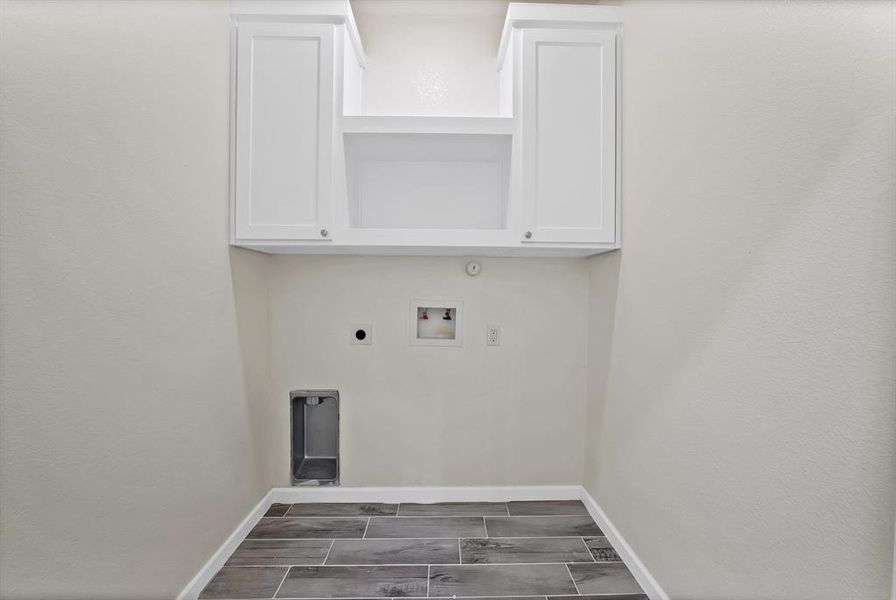 Laundry area with electric dryer hookup, washer hookup, and wood finish floors