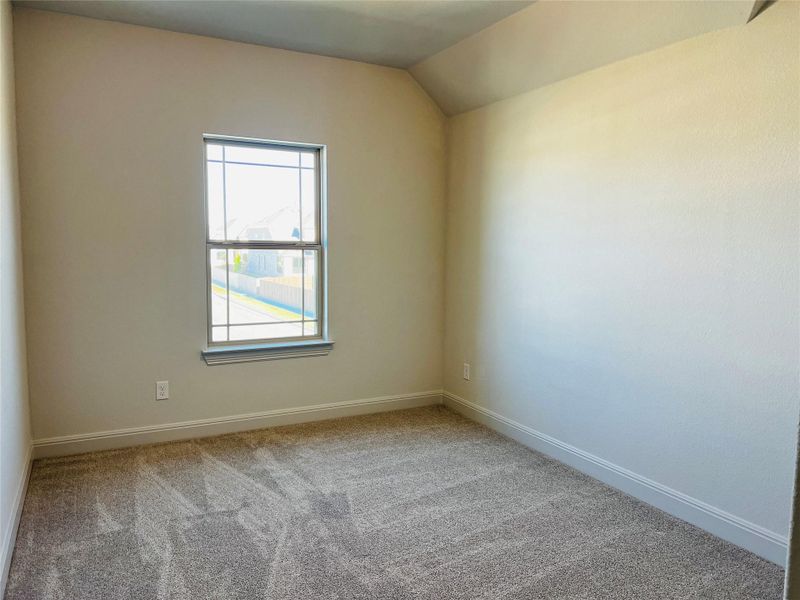 Empty room featuring light colored carpet and baseboards