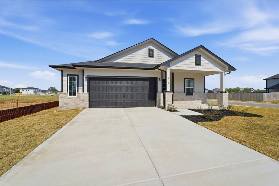 Front exterior of a new home in Paramount, Kyle, TX, highlighting curb appeal (Image 22).