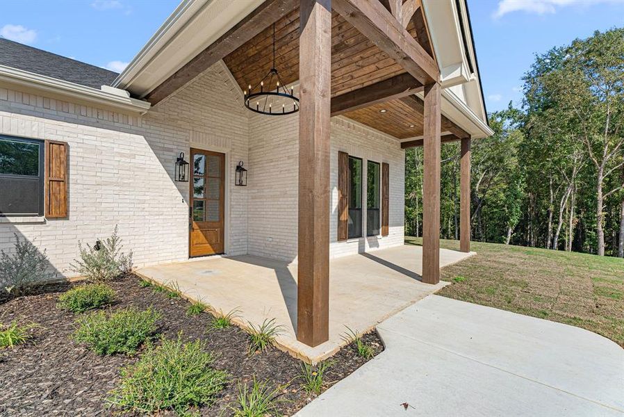 Entrance to property with brick siding and a patio