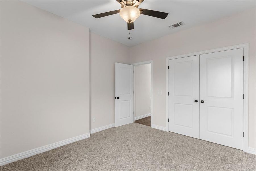 Unfurnished bedroom featuring a closet, ceiling fan, and carpet flooring Unfurnished bedroom featuring a closet, ceiling fan, and carpet flooring