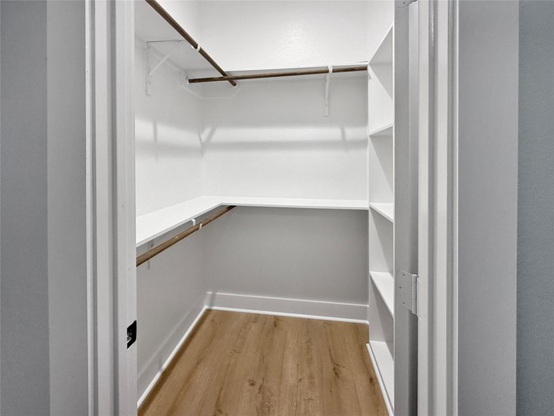 Spacious master walk-in closet with ample storage and organized walk-in closet with built-in shelving, hanging rods, and ample space for your wardrobe.