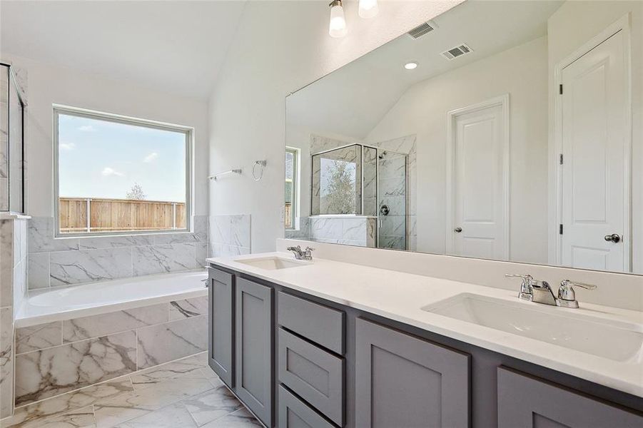 Bathroom with vanity, shower with separate bathtub, and lofted ceiling