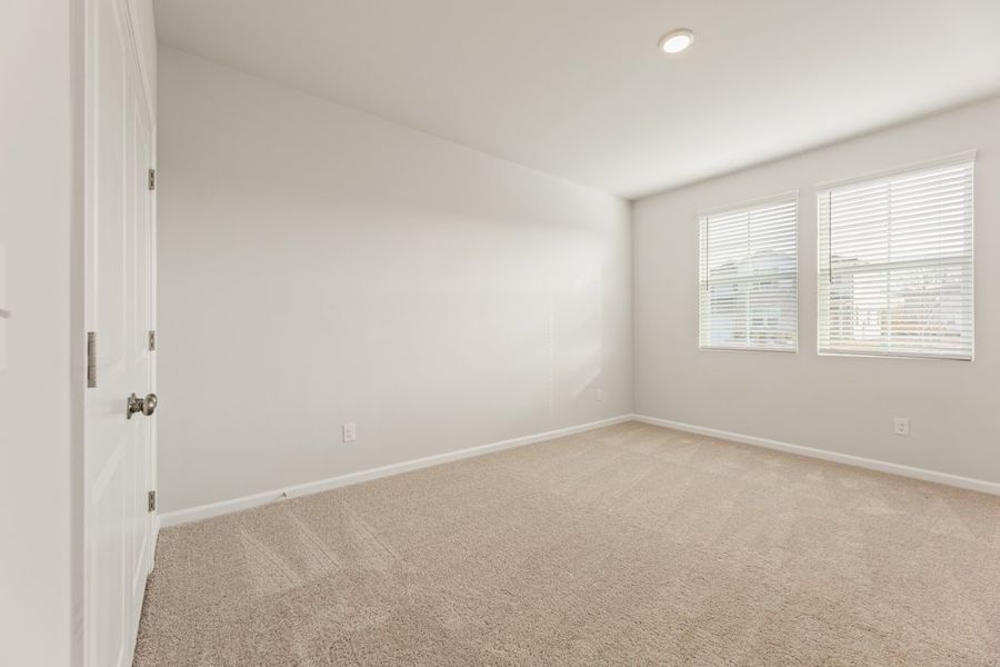 A room with a carpet and a door.