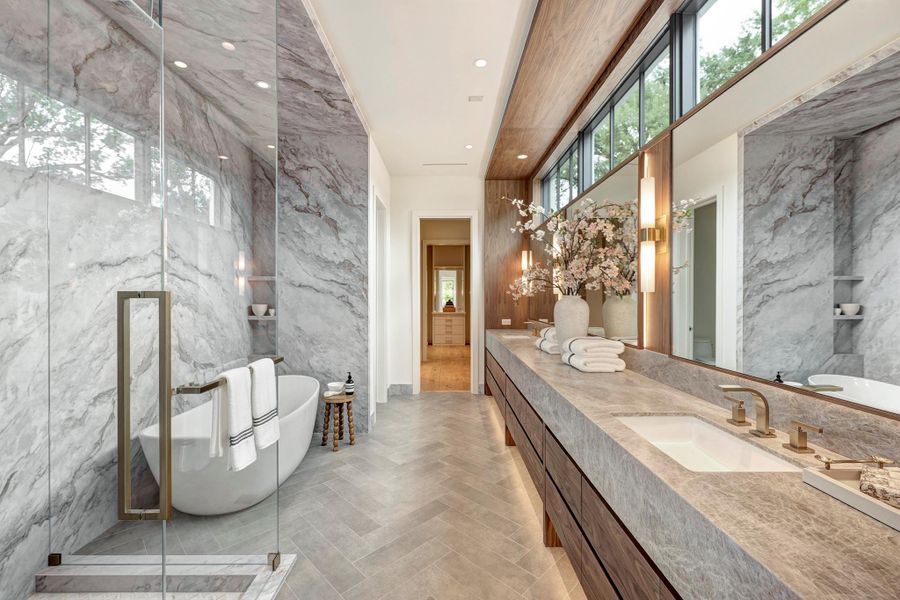 Natural light pours through high windows, while Taj Mahal walls and counters create a calm, spa-like retreat.