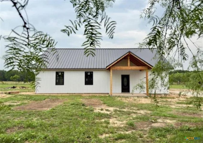 Rear view of house featuring a patio area and a lawn