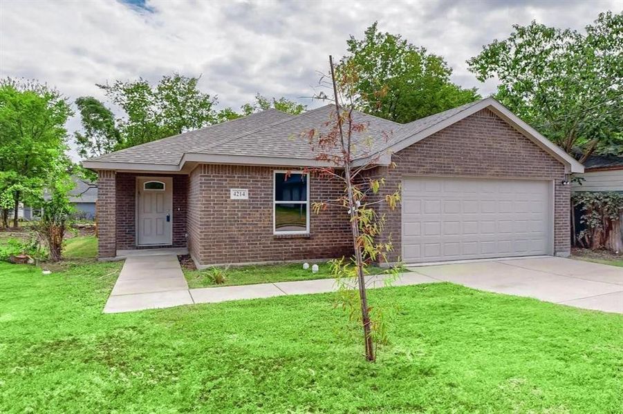 Ranch-style house featuring a garage and a front lawn