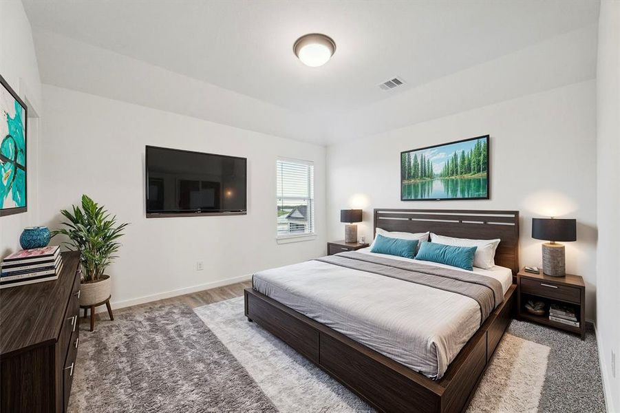 This virtually staged secondary bedroom offers a cozy and inviting space, complete with soft carpeting and large windows that fill the room with natural light. It's the perfect spot for rest and relaxation, providing comfort and privacy.