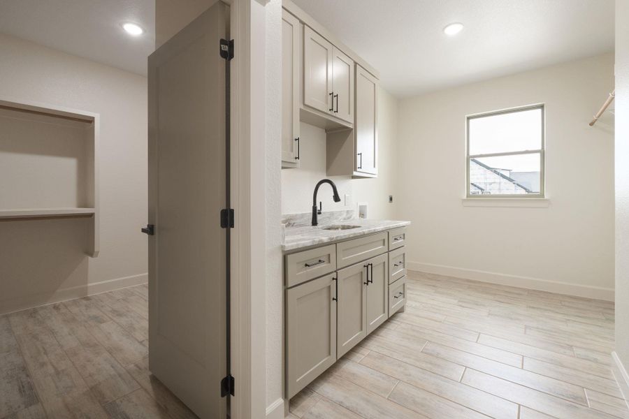 Laundry room with light wood-style flooring, cabinet space, recessed lighting, hookup for a washing machine, and electric dryer hookup