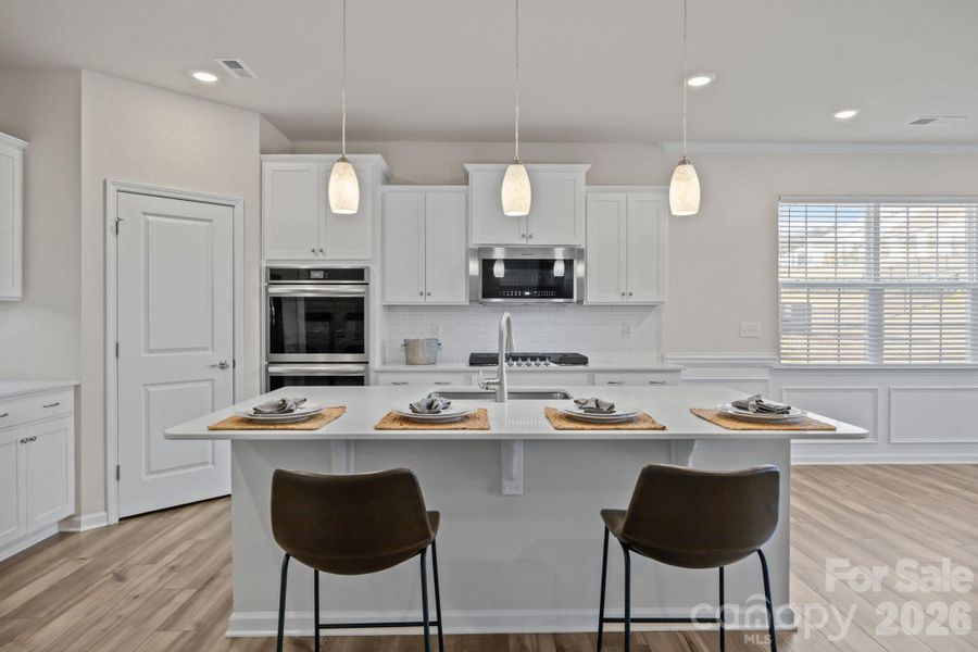 This magnificent island draws you in to enjoy the kitchen space and visit a while longer! The neutral decor, drop down pendant lighting and GOURMET upgrade in appliances speak quality.