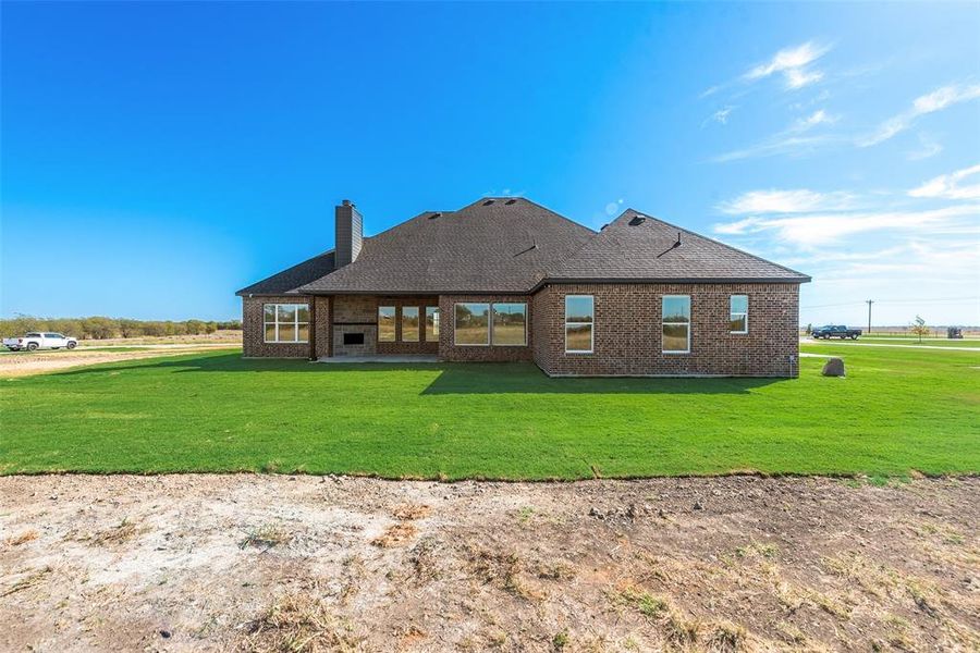 Rear view of property with a lawn