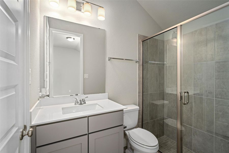 Guest or secondary bathroom featuring a walk-in shower with modern tile and glass enclosure.