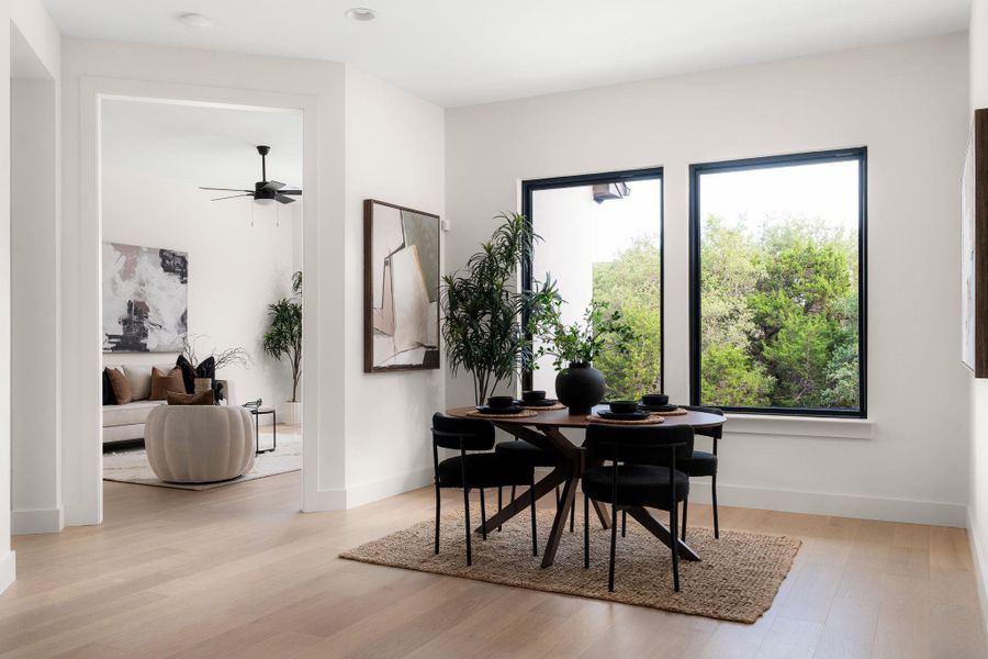 Hardwood floors and generous natural illumination complement this versatile open-concept dining space.