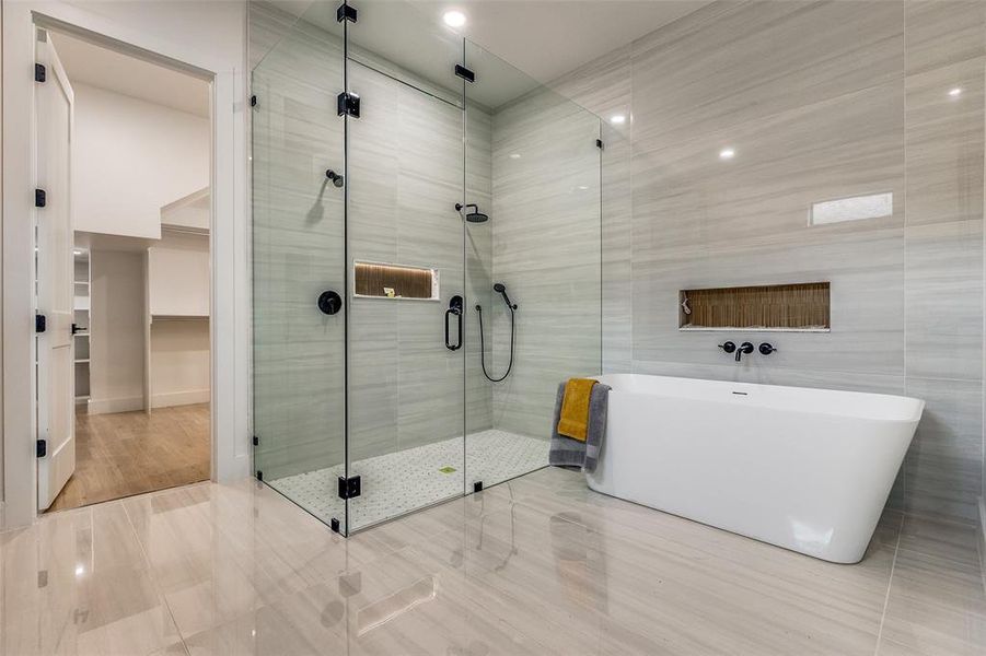 Bathroom featuring tile patterned flooring, tile walls, and independent shower and bath