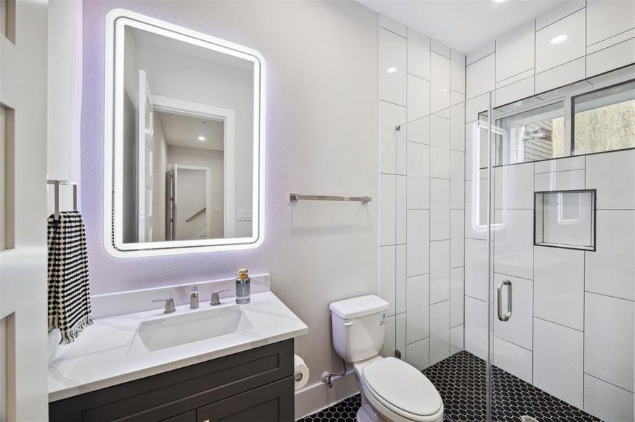 First floor bathroom has a quartz counter on the vanity and a glass enclosed shower.