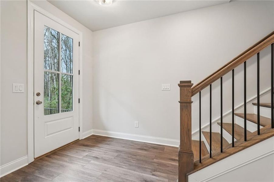 Foyer featuring stairway and wood finished floors