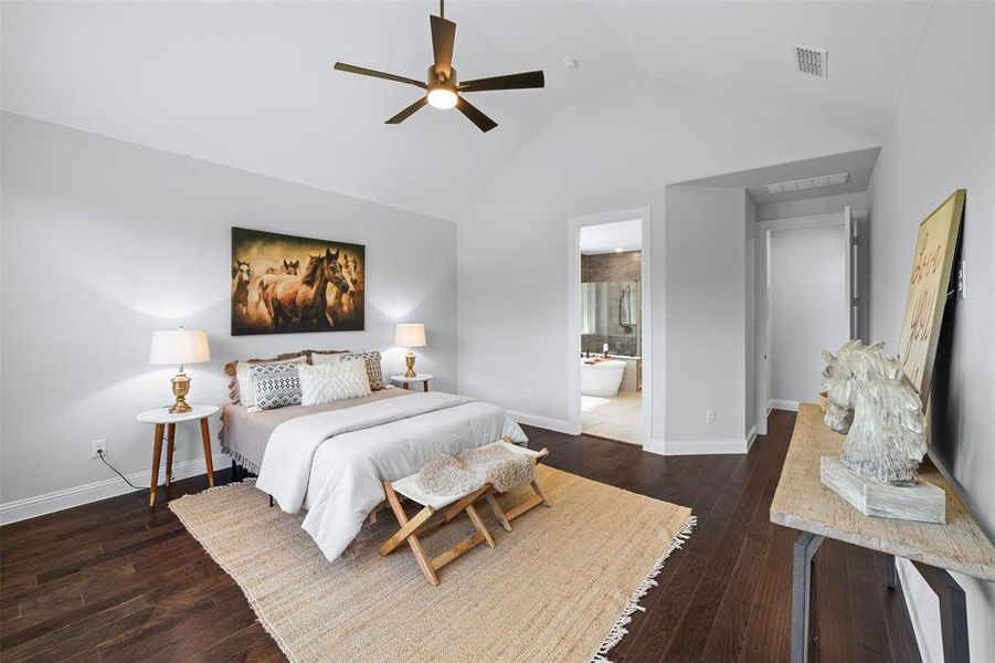 Bedroom featuring hardwood / wood-style floors, high vaulted ceiling, connected bathroom, and a ceiling fan