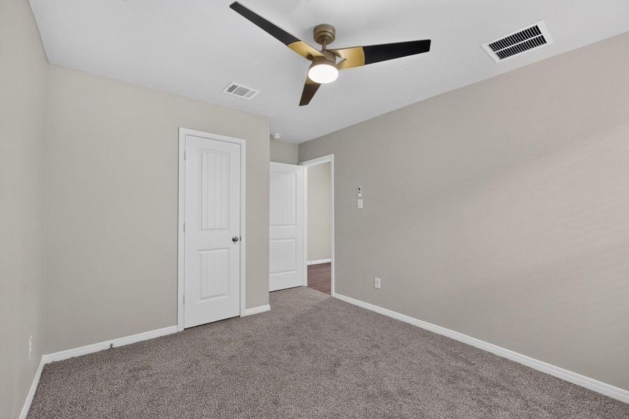 Plush carpeting anchors this versatile interior space featuring clean baseboards and neutral walls.