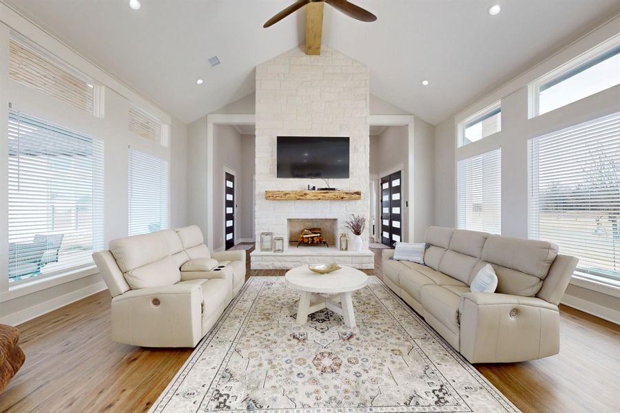 Builderes plans show 4020 SF, 4 bedrooms 3.5 baths, office, summer kitchen, Butlers Pantry, One Spacious living area plus a bonus room.  This gorgeous living room is open to the kitchen and dining, featuring a vaulted ceiling with exposed wood beam, a large white stone gas lit but wood burning fireplace with a wood mantel, and wood-finish flooring.  Each room has a ceiling fan.  A second living area can be made of the only room upstairs, the bonus room.  Electrical outlet above the fire place for a large TV