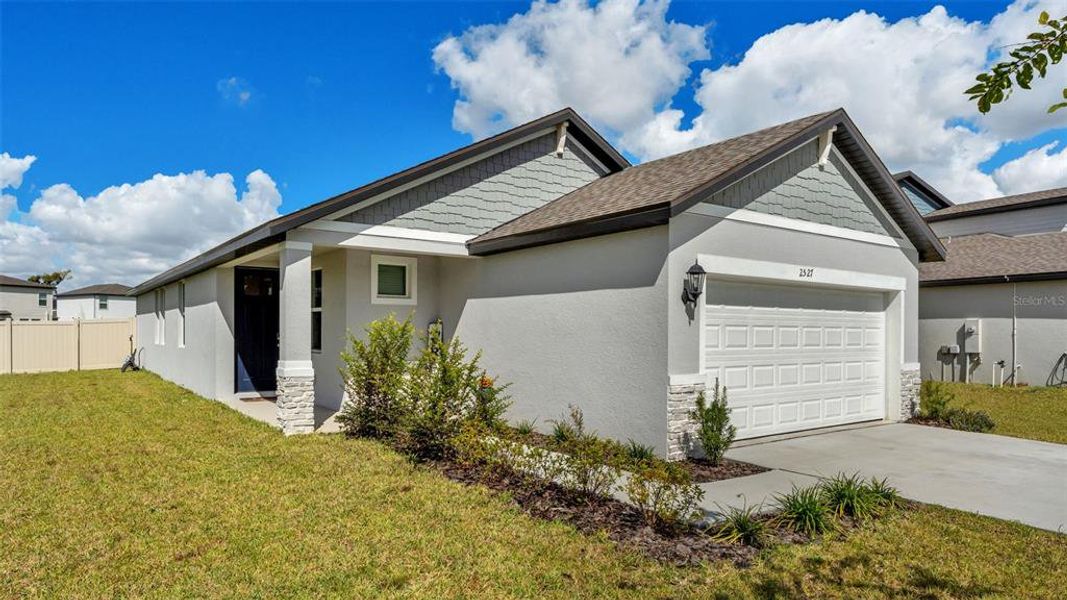 Front exterior of a new home in The Grove at Stuart Crossing - Premier Series, Bartow, FL, highlighting curb appeal (Image 2).