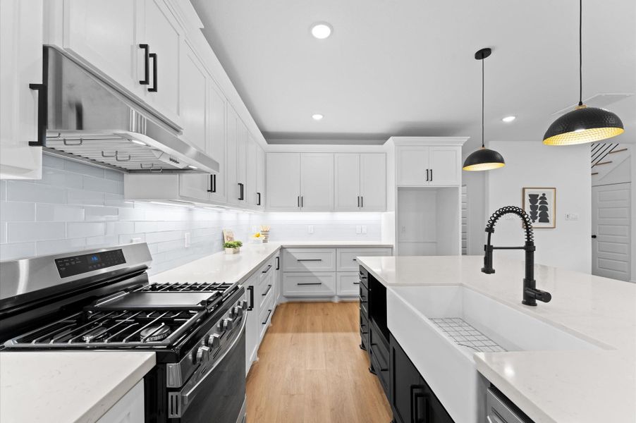 Quartz counters, subway tile backsplash, under-cabinet lighting, and an apron front sink...this kitchen has it all!