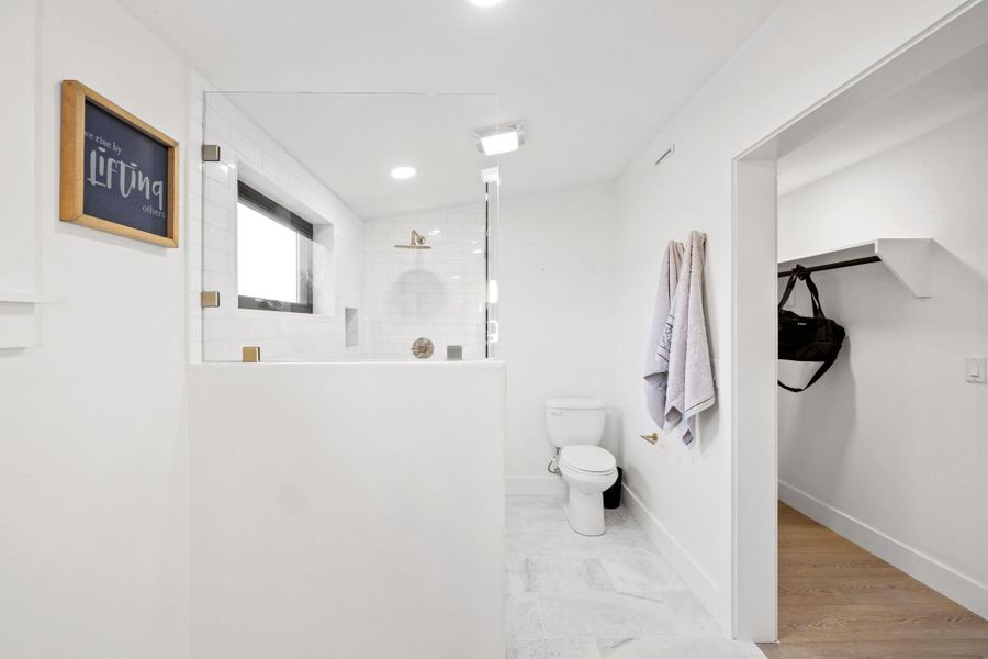 Bathroom with toilet, baseboards, and walk in shower