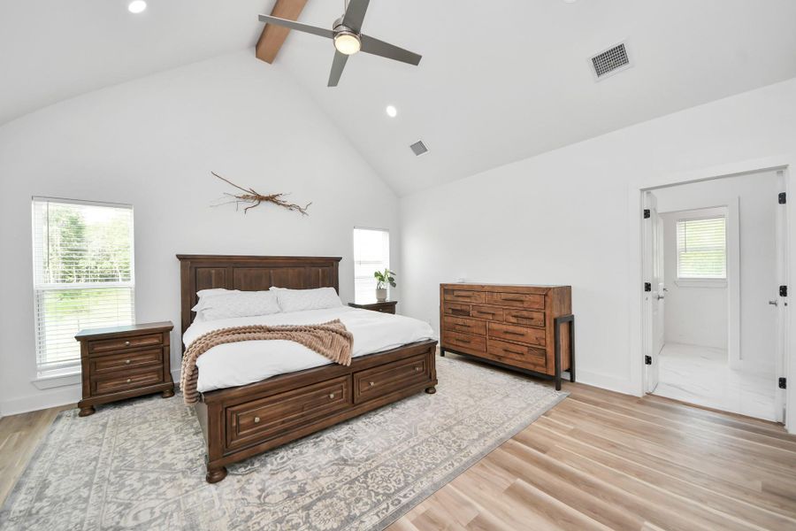 Spacious Primary Bedroom with vaulted ceilings, featuring abundant natural light. Elegant hardwood floors and an en-suite bathroom offering convenience and privacy. Spacious Primary Bedroom with vaulted ceilings, featuring abundant natural light. Elegant hardwood floors and an en-suite bathroom offering convenience and privacy.