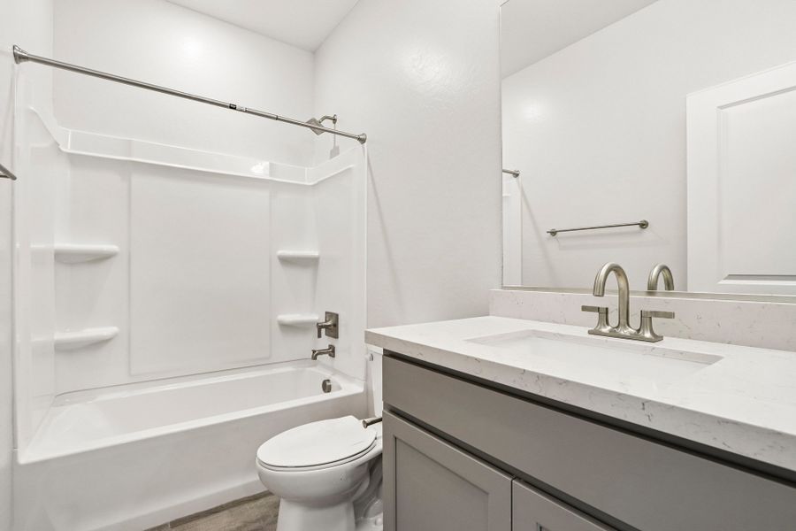 A bathroom with a tub sink and toilet.