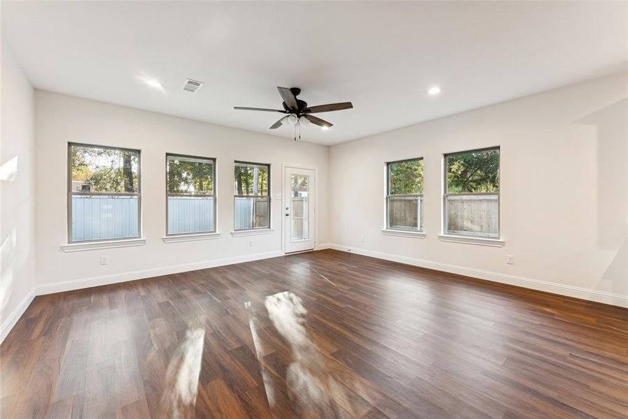 Empty room with dark wood-type flooring, recessed lighting, and a ceiling fan