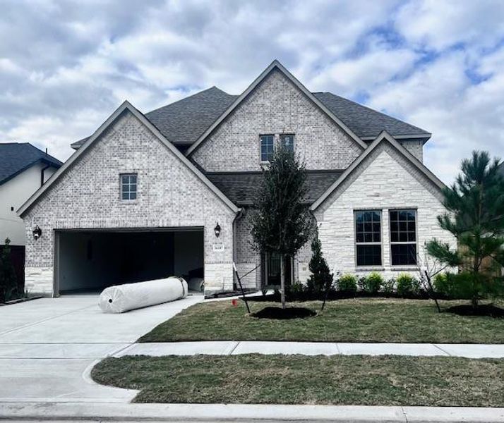 Front exterior of a new home in Evergreen 55', Conroe, TX, highlighting curb appeal (Image 1).