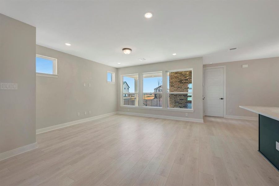 Empty room featuring light wood-type flooring and recessed lighting