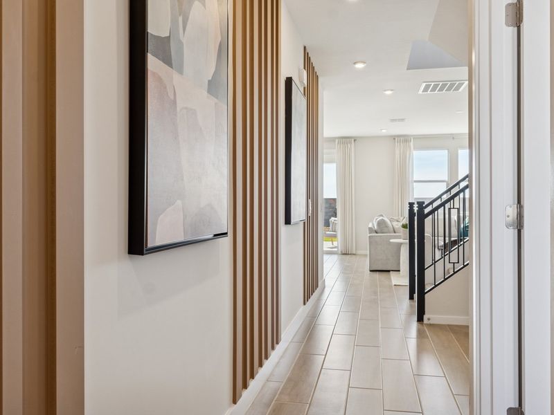 A hallway with a railing and a door with a painting on the wall. A hallway with a railing and a door with a painting on the wall.