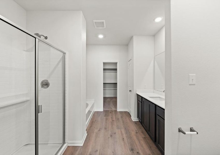 The master bathroom has a large walk-in, glass shower and a garden tub.