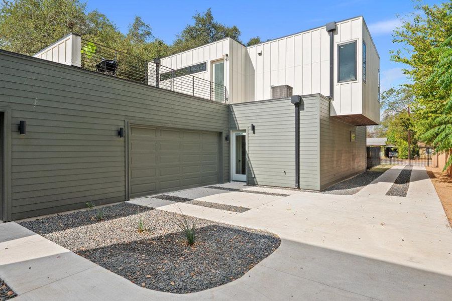 View of home's exterior featuring board and batten siding, an attached garage, and driveway