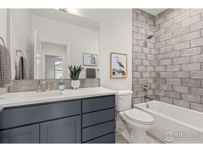 The full guest bath, which also features full-height tile shower surround