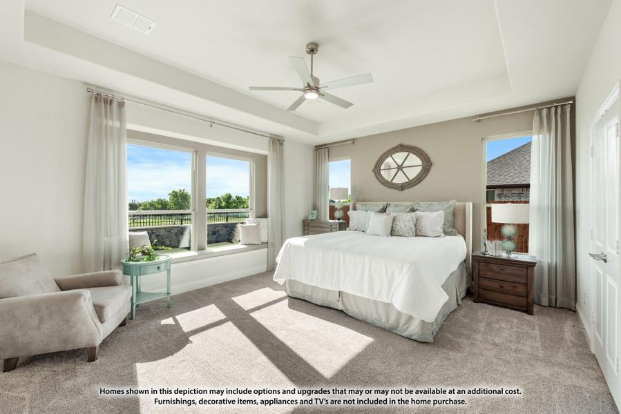 Master bedroom with tray ceiling, ceiling fan, large windows, and neutral carpet flooring