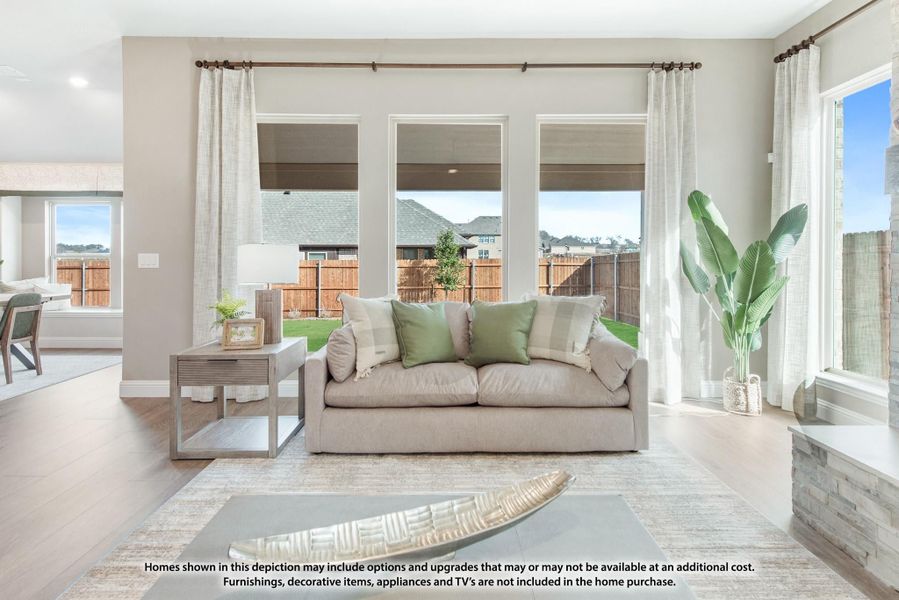 Living room with beige sofa, large windows, hardwood floors, and open view to backyard Living room with beige sofa, large windows, hardwood floors, and open view to backyard